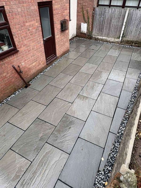 Grey Indian stone paving laid along the side of a house in Bersham, Wrexham