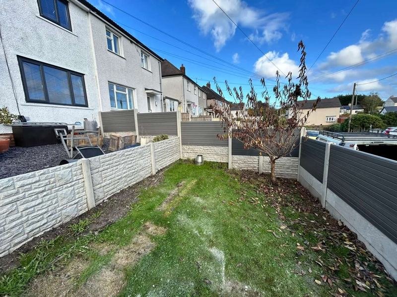 Composite fence panels above a concrete retaining wall in Gwynfryn, Wrexham