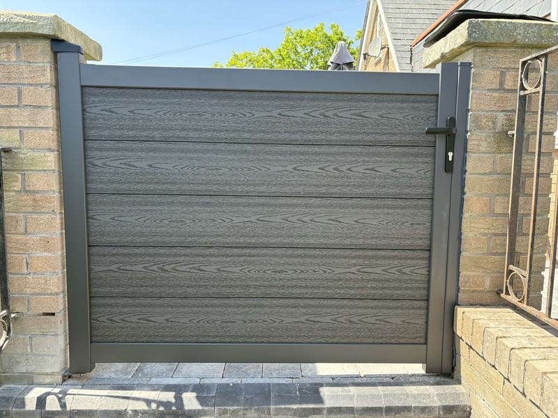 Grey composite gate between brick pillars in Borras, Wrexham