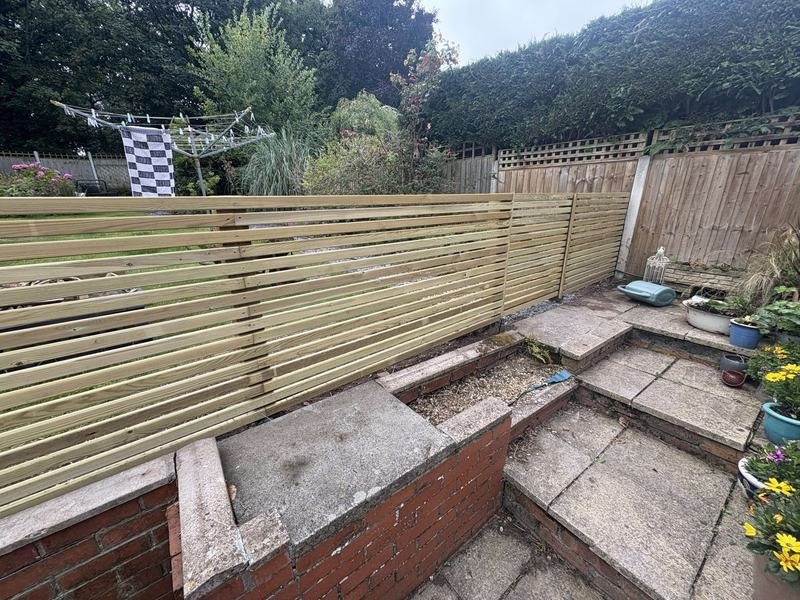 Contemporary slatted fence enclosing a patio in Summerhill, Wrexham