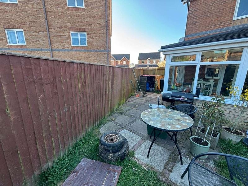 Bespoke timber gates and fencing beside a conservatory in Brymbo, Wrexham