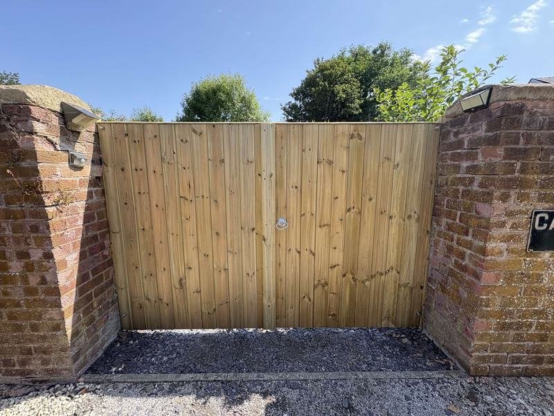 Tall tongue and groove gate between brick pillars in Caegwrle, Wrexham