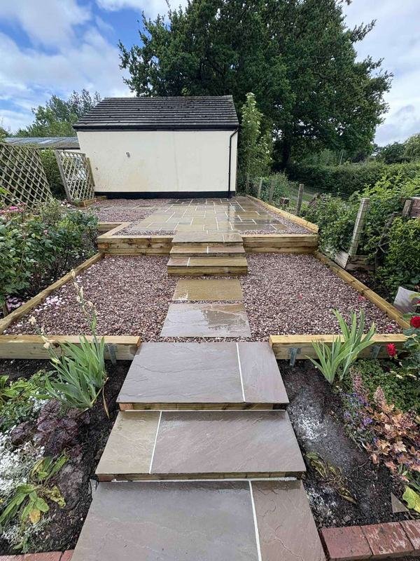 Indian sandstone stepping path between planted borders in Rossett, Wrexham