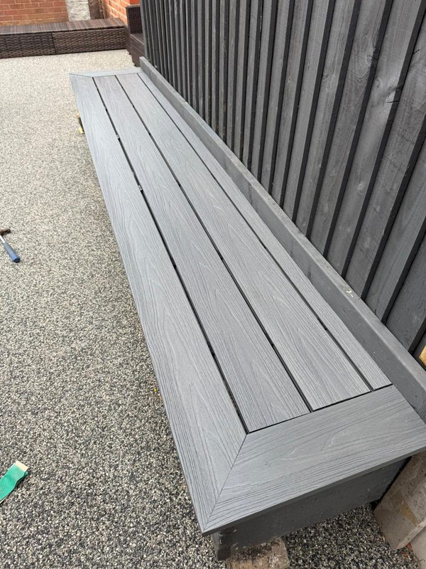 Grey composite decking boards capping a garden bench in Rhosllanerchrugog, Wrexham