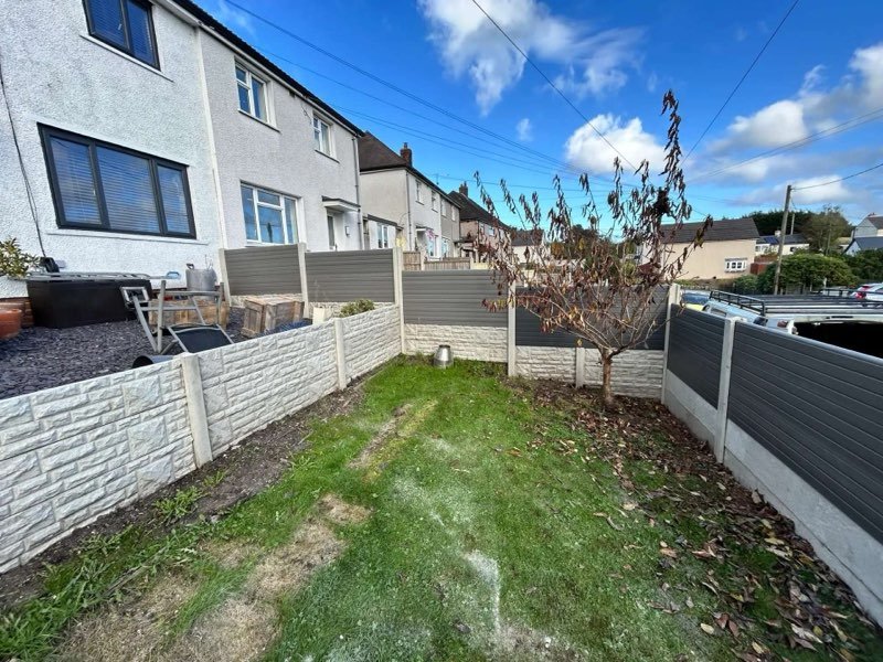 Grey composite fencing above a concrete retaining wall in Gwynfryn, Wrexham