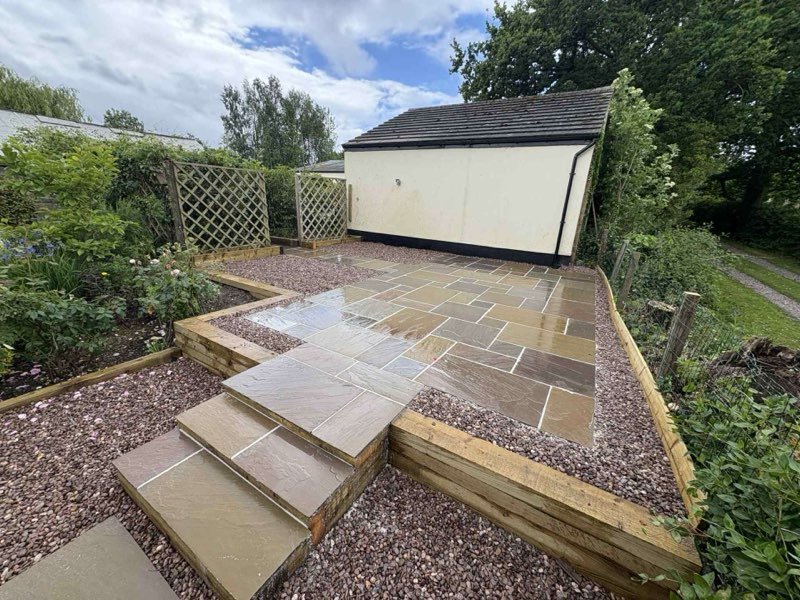 Raj blend Indian sandstone paving with sleeper retaining walls and gravel detail in Rossett, Wrexham