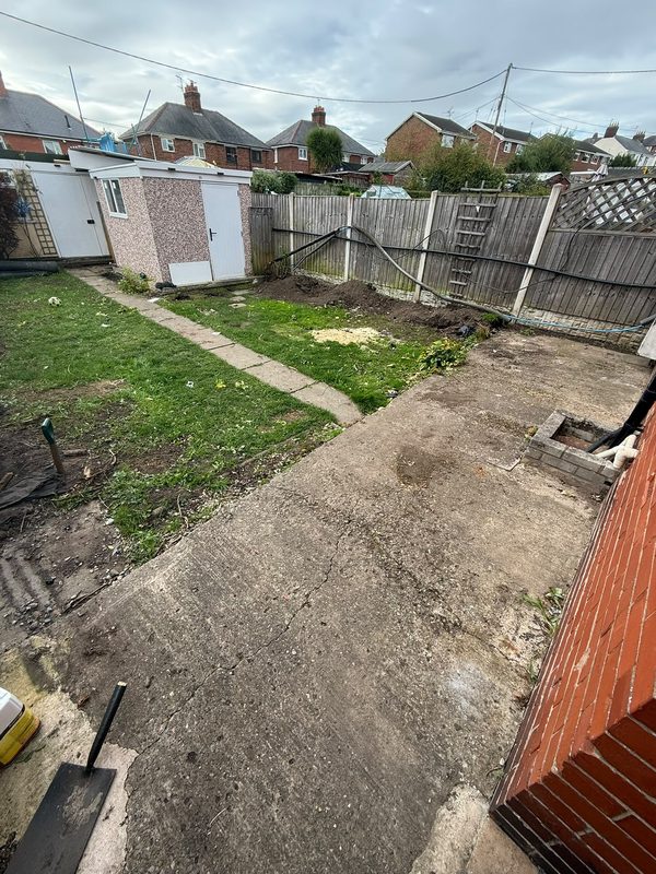 The old cracked concrete slab along the house and the worn lawn before the dig-out in Gwersyllt