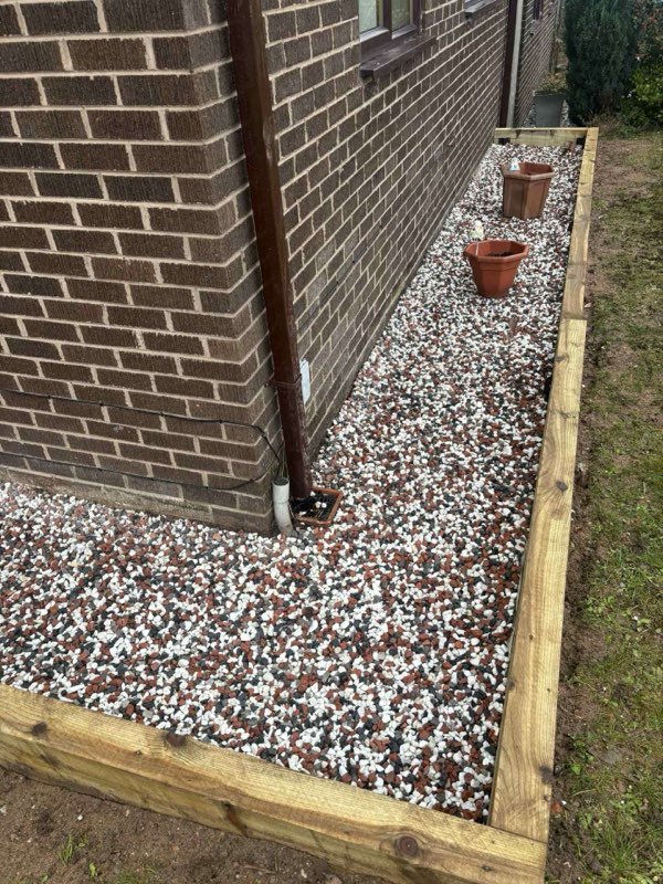 Picket fencing and a sleeper retaining bed alongside a conservatory in Borras, Wrexham