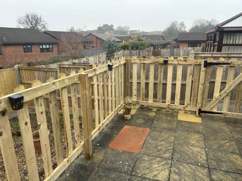 Picket fencing and a sleeper retaining bed alongside a conservatory in Borras, Wrexham