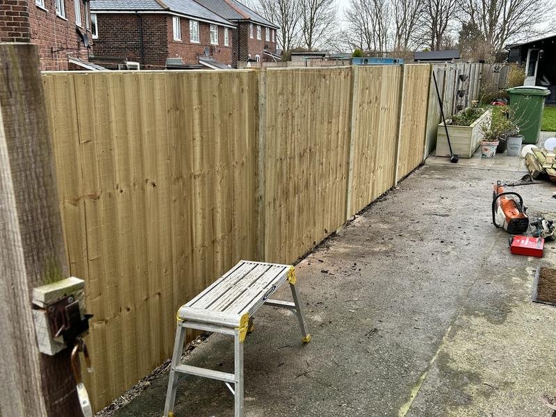 New timber fence replacing a storm-damaged run on a sloping garden in Brymbo, Wrexham