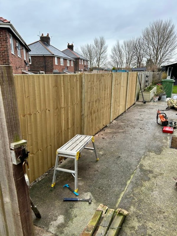 New timber fence replacing a storm-damaged run on a sloping garden in Brymbo, Wrexham