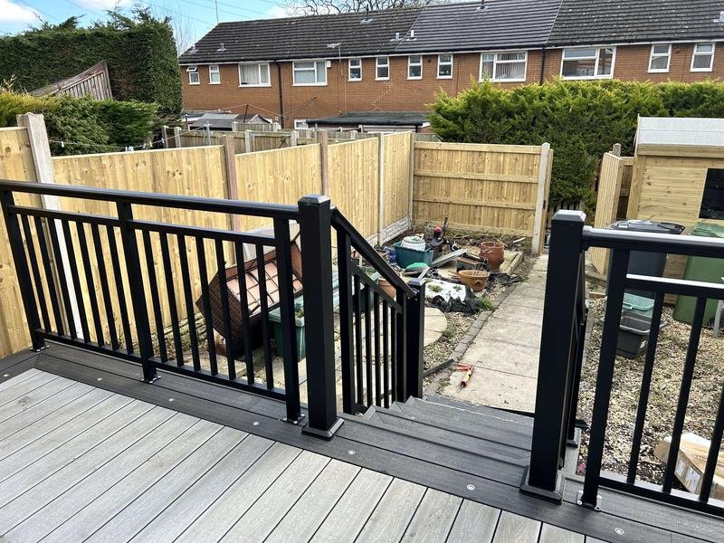 Grey composite decking with black aluminium balustrades and steps replacing an old timber deck in Tan-y-Fron, Wrexham