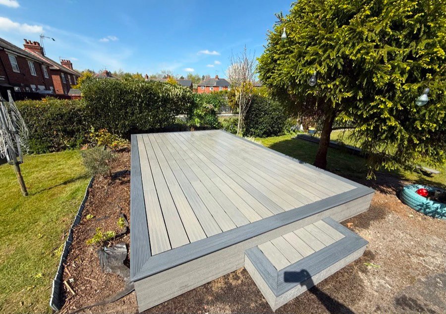 Raised grey composite decking platform with a step, built in a Wrexham garden