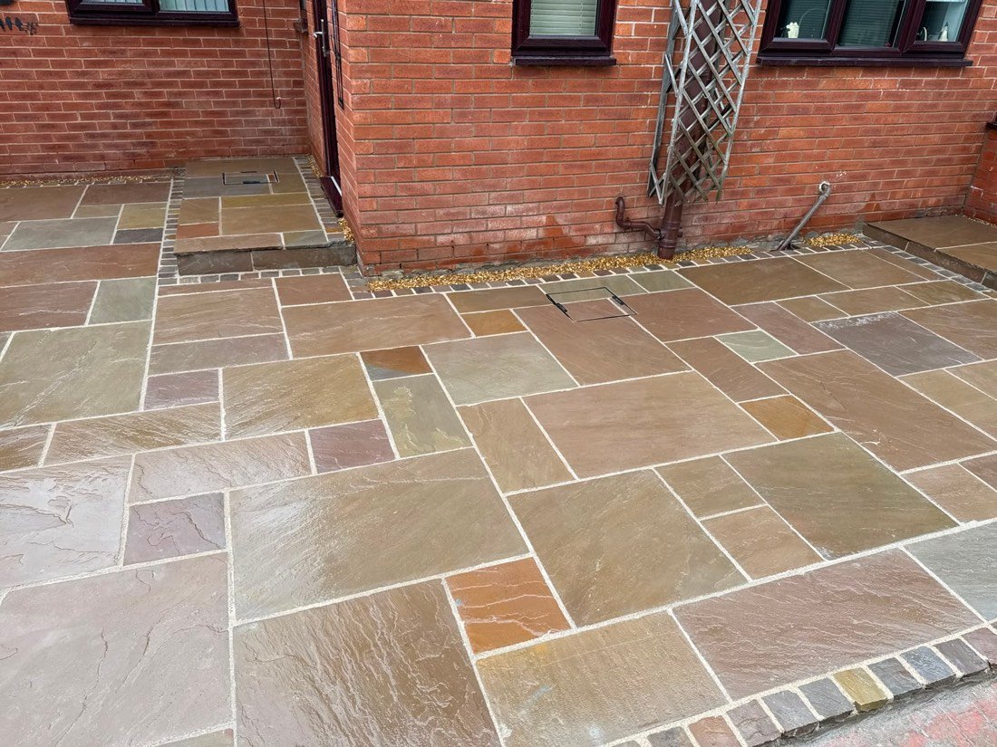 Autumn brown Indian sandstone patio with sett detail and a raised step, Wrexham